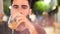 Young man drinking cocktail outside at night