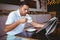 Young man drinking cup of coffee reading newspaper