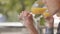 Young man drinking orange juice sitting in modern cafe close-up. The male visitor sitting at the table tasting his