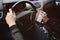 Young man driving a car with an iron flask