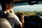 Young man driving car over nature hills background