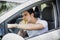 Young man driving his car while eating food