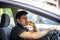 Young man driving his car while eating food