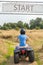 Young man driving quad with start banner