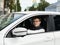 Young man is driving white car. Portrait