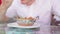 A young man is eating an Indian meat dish in a tropical cafe.