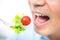 Young man eating salad, close up