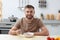 Young man eating tasty vegetable soup at table