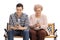 Young man and elderly woman on bench looking at phones