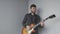 Young man with electric guitar playing and preparing for concert. Handsome man with beard holding guitar and playing rock and blue