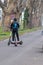 Young man on electric scooter with a second scooter for recharge working as juicer in urban city life style of eco friendly life