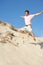 Young Man Enjoying Beach Holiday Running Down Dune