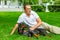 Young man enjoying a sunny day in the park with his dog. dobermann. They are playing together lying on the green grass.