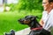 Young man enjoying a sunny day in the park with his dog. dobermann. They are playing together lying on the green grass.