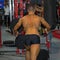 Young Man Exercising with Fitness Machine at Gym: Back view