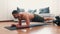 Young man exercising at home. Camera moves to right during plank exercise. Strong powerful man exercising alone in