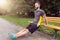 Young man exercising using a wooden park bench