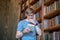 Young man in eyewear reading a book and loooking involved