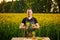 A young man farmer or agronomist examines the quality of rapeseed oil on a rape field. Agribusiness concept