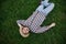 Young man farmer in a straw hat lying on the green grass, top view