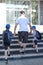 Young man, father leads two children with school bags, hold hands, climb the stairs, Back to school concept