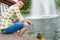 Young man feeding ducks in a pond