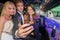 Young man with female friends taking selfie on mobile phone in l