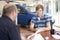 Young man filling in paperwork in car showroom