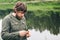 Young Man Fisherman bearded standing with knife and rod Lifestyle