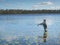 Young man fishing with spinning in lake. Ecotourism, visiting fragile, pristine, undisturbed