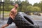 Young man flipping a tire. Heavy workout in a rainy day.