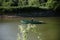 Young man floats on a wooden boat with oars