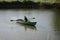 Young man floats on a wooden boat with oars