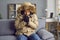 Young man freezing in cold winter and wearing coat inside house without central heating