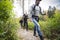 Young Man With Friends Hiking On Forest Trail