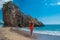 Young man in front of beautiful rocks on pebble public stone beach. Rafailovici esort towns. Mountenegro. Adriatic Sea