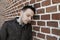 Young man in front of the brick wall