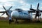 A young man in front of an old abandoned Soviet plane.