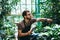 Young man gardener in glasses with digital tablet working in a garden center