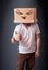 Young man gesturing with a cardboard box on his head with evil f