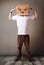 Young man gesturing with a cardboard box on his head with evil f