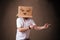 Young man gesturing with a cardboard box on his head with evil f