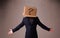 Young man gesturing with a cardboard box on his head with question mark