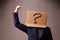 Young man gesturing with a cardboard box on his head with question mark