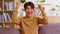 Young man gesturing Yes, smiling at camera to celebrating successful. Posing on couch in the living room. Portrait of Asian guy