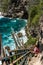 Young man getting down the cliff to beautiful cove