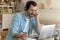 Young man getting remote education sitting by laptop in headphones