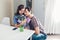 Young man gifting bouquet of flowers to his girlfriend in kitchen. Happy couple hugging. Romantic surprise