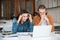 Young man and girl tiredly looking on laptop while working together in office. Young amazed students sitting at