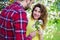 Young man giving flowers to happy girlfriend in garden